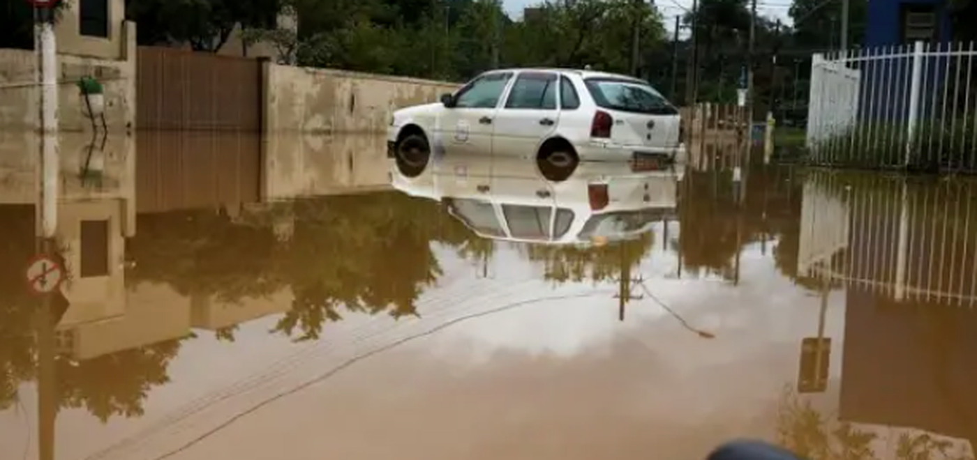 Rua alagada com carro em meio à água